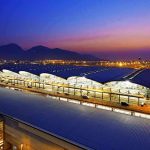 Trump Reveals Major D.C Airport Overhaul Airport terminal at dusk with illuminated wave-like roof