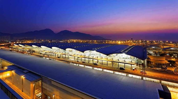 Airport terminal at dusk with illuminated wave-like roof