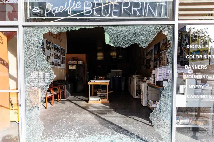 Shopfront with large shattered glass window opening into print shop