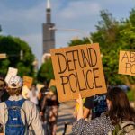 protesters holding cardboard signs during a street march