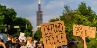 protesters holding cardboard signs during a street march