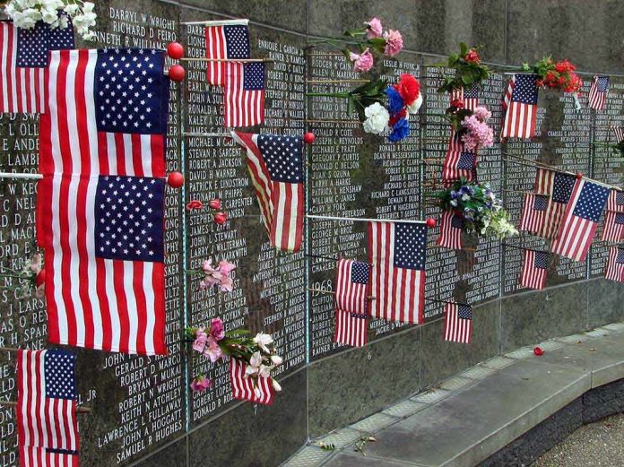 shutterstock_17555125 Memorial wall adorned with American flags and flowers