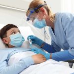Nurse checks temperature of hospitalized boy