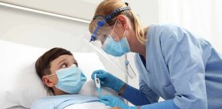 Nurse checks temperature of hospitalized boy