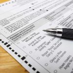 Ballot paper with pen on wooden surface