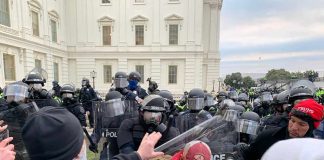 Dontrelle Inman among protesters and police in riot gear outside a government building