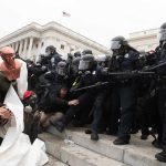 Eric Tingstad amid police and protesters clashing on steps outside a government building