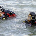 Ancient Lake Drys Up Revealing 1,000 Year-Old Artifacts! two divers in full-face masks floating in choppy water