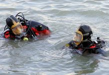 Ancient Lake Drys Up Revealing 1,000 Year-Old Artifacts! two divers in full-face masks floating in choppy water