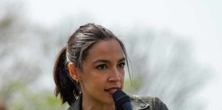 AOC Reveals When She’ll Make Her 2028 Decision AOC speaking into a handheld microphone outdoors