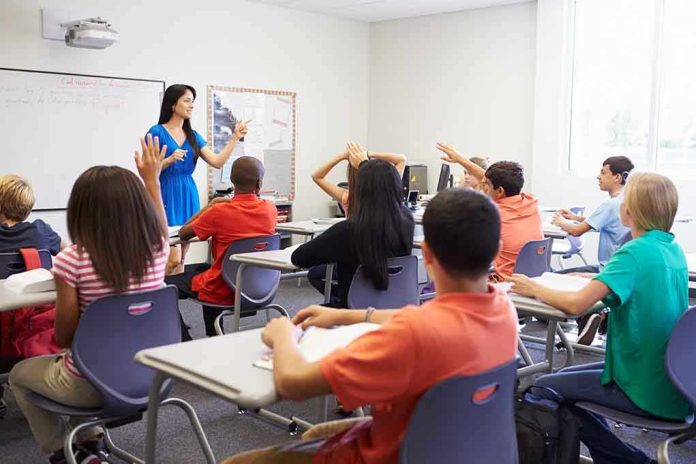 shutterstock_199144970 Teacher leading classroom discussion with students raising hands