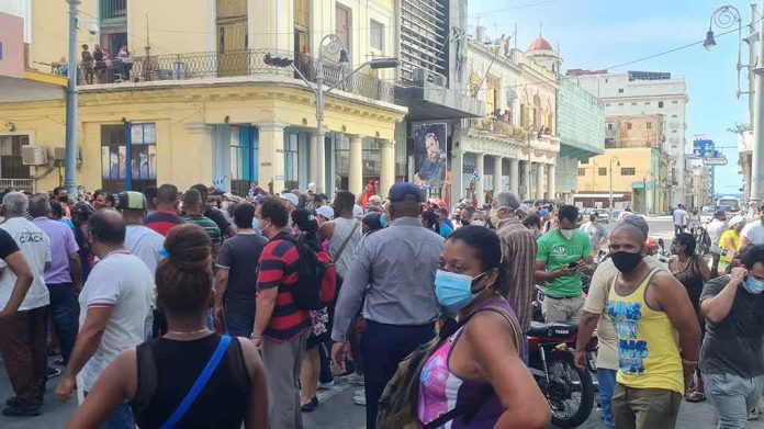 crowd of people wearing masks gathered on a city street