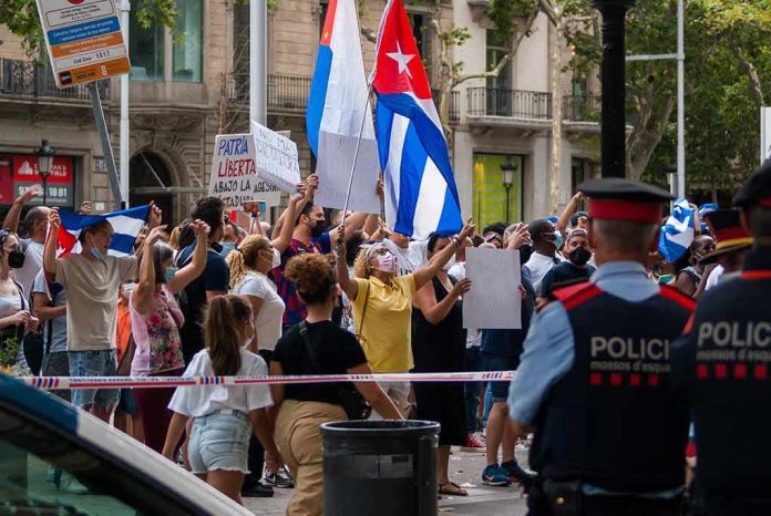 shutterstock_2006658818 Walter Jones amid crowd at street protest with Cuban flags and police present