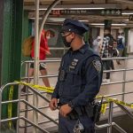 Subway Fight Turns Deadly – Man KILLED! Police officer stands in a subway station near caution tape