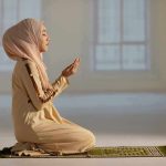 Tax-Funded Ramadan Sparks Lawsuit – OUTRAGE! Woman in hijab praying on a mat indoors