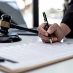 Migrant Psycho Kills 3 Then Blames THIS Hand signing legal document beside gavel and laptop