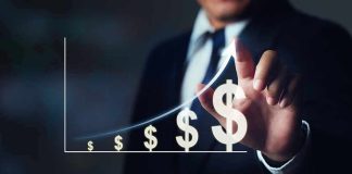 Businessperson points to rising dollar symbols on a growth chart