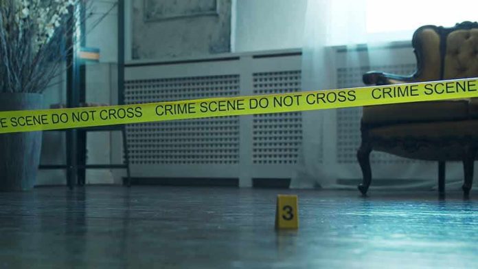 Crime scene tape across a room with evidence marker on floor