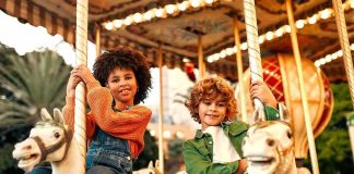 Children riding carousel horses at an amusement park