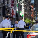 police officers and investigator at a taped-off city sidewalk
