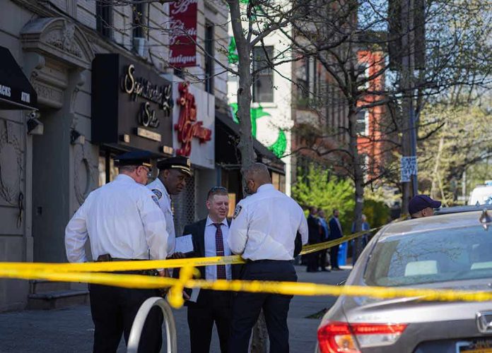 shutterstock_2289044011 police officers and investigator at a taped-off city sidewalk