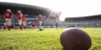 American football on a grass field at a stadium
