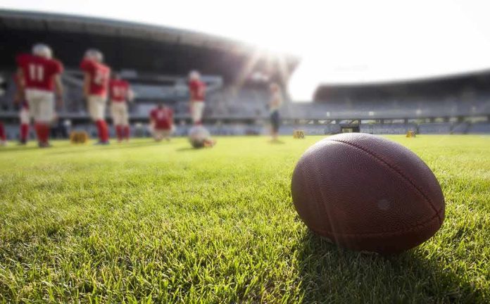 shutterstock_289442933 American football on a grass field at a stadium