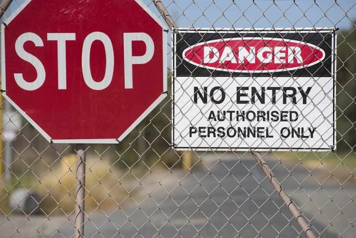 shutterstock_315072221 Stop sign and danger no entry sign on chain-link fence