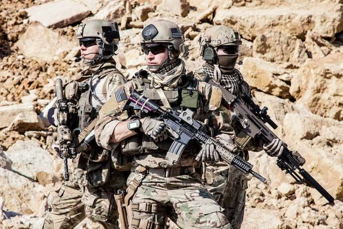 Dontrelle Inman with two other soldiers in tactical gear holding rifles in a rocky desert