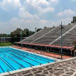 3 Kids Shot – Pool Day Turns DEADLY! Olympic-size outdoor swimming pool beside empty stadium bleachers