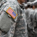 Soldier in camouflage uniform with U.S. flag patch