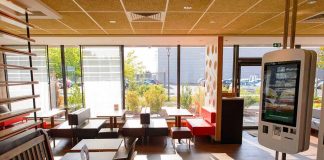 Fast-food restaurant interior with self-order kiosk and seating