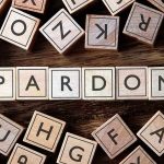 Governor Pardons Illegals Days Before Leaving Office! Wooden letter blocks arranged to spell 'PARDON' on a wooden surface