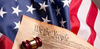 U.S. Constitution with gavel on American flag