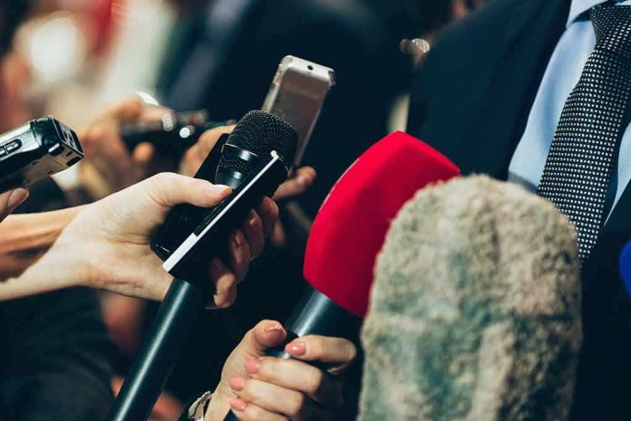 shutterstock_461773729 Microphones held up to a speaker in a suit