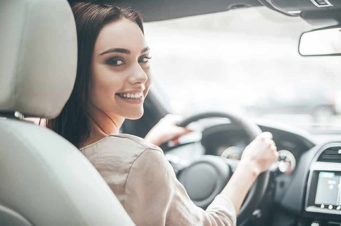 Woman driving a car and smiling over her shoulder