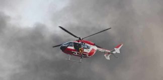 Rescue helicopter hovers amid thick smoke
