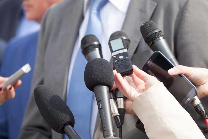 shutterstock_618881507-1 Microphones held toward a person in a suit