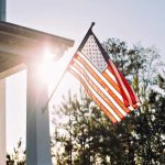 American flag on a house porch at sunset
