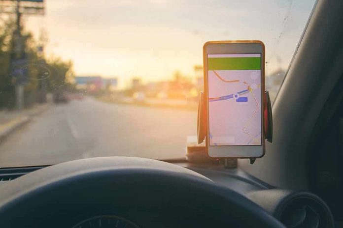 shutterstock_769668427 smartphone with map app on car dashboard at sunset