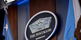 PENTAGON LIVESTREAMS A Firing Squad The Pentagon emblem between two flags.