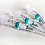 WHO Demand Toddlers Receive STD Vacs! Three syringes filled with blue-green liquid on a white surface