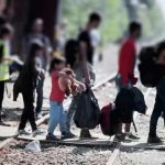 Hundreds of Child Marriages Reported in Migrant Communities People with bags walking along railway tracks