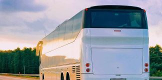 White coach bus driving on a highway at sunset