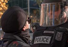 Anti-ICE Agitators Fuel Riot Mayhem protester faces police officer in riot gear