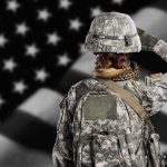 Pentagon Withholding Records on ‘Effectiveness’ of Women in Combat Soldier in camouflage saluting before a U.S. flag