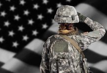 Pentagon Withholding Records on ‘Effectiveness’ of Women in Combat Soldier in camouflage saluting before a U.S. flag