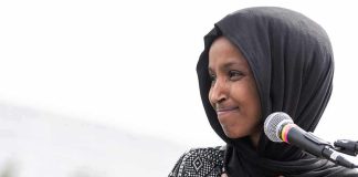 What FBI Found During Ilhan Omar Raid Will Stun You Ilhan Omar speaking at a microphone with hand on chest