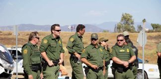Sid Fernandez and Bear Pascoe among uniformed officers standing near traffic cones outdoors