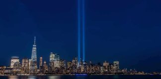At the Request of Families, Trump Weighs Declassification of 9/11 Records City skyline at night with twin blue light beams rising into the sky
